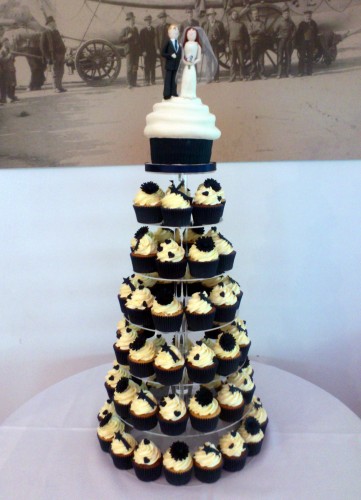 wedding cupcake tower with giant cupcake bride and groom topper