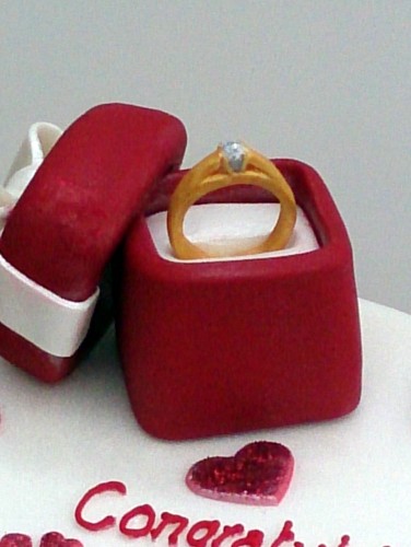 2 tier heart shaped engagement cake with ring in a box