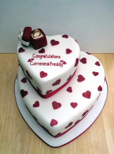 2 tier heart shaped engagement cake with ring in a box