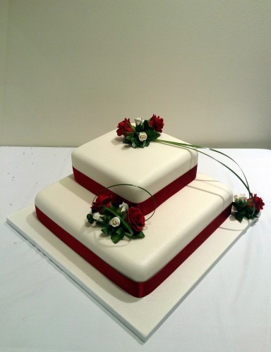 2 tier square stacked wedding cake with deep red rose sugar flower spray