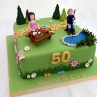 joint 50th birthday cake with a garden fishing and crafting theme