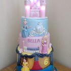 4 tier disney princesses birthday cake with an illuminated castle