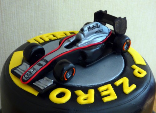 F1 pirelli tyre themed 3 tier wedding cake with bride and groom and F1Mclaren racing car