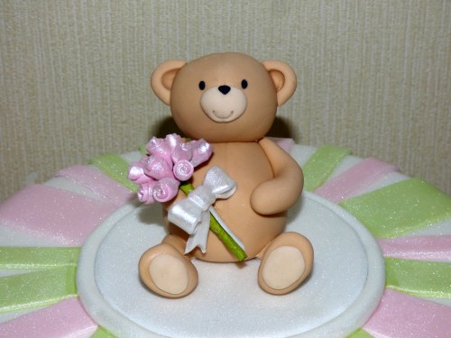 simple striped birthday cake with bear carrying a bouquet of roses