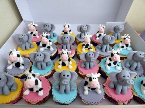 twins 11th birthday cake with cow and elephants and cupcakes