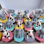 twins 11th birthday cake with cow and elephants and cupcakes