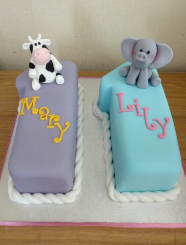 twins 11th birthday cake with cow and elephants and cupcakes