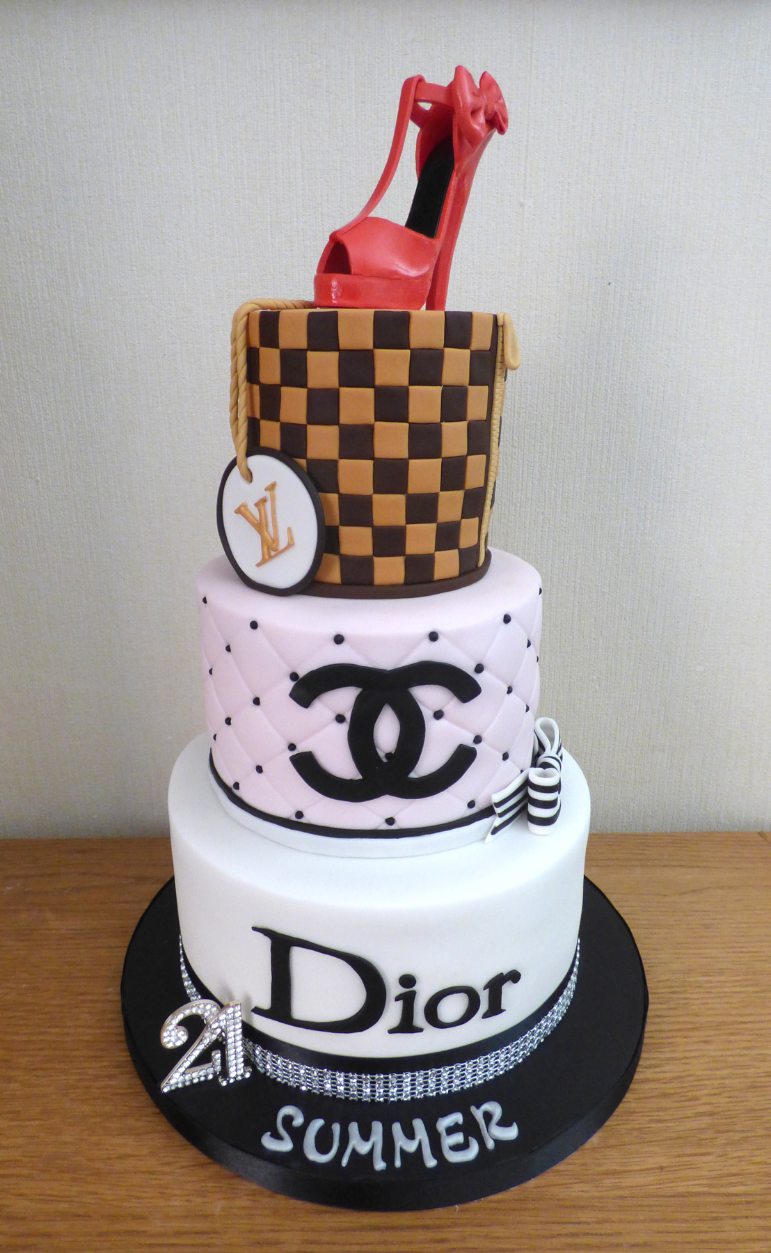 3 tier designer cake . Louis Vuitton high heel topper, Gucci top tier,  Chanel middle tier and Versace base tier . Cake Flavor: Wedding cake
